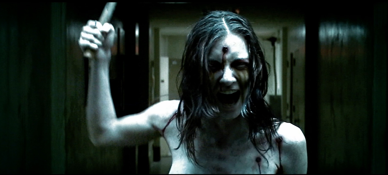 Mary Hatchet raises a knife in a dark hallway