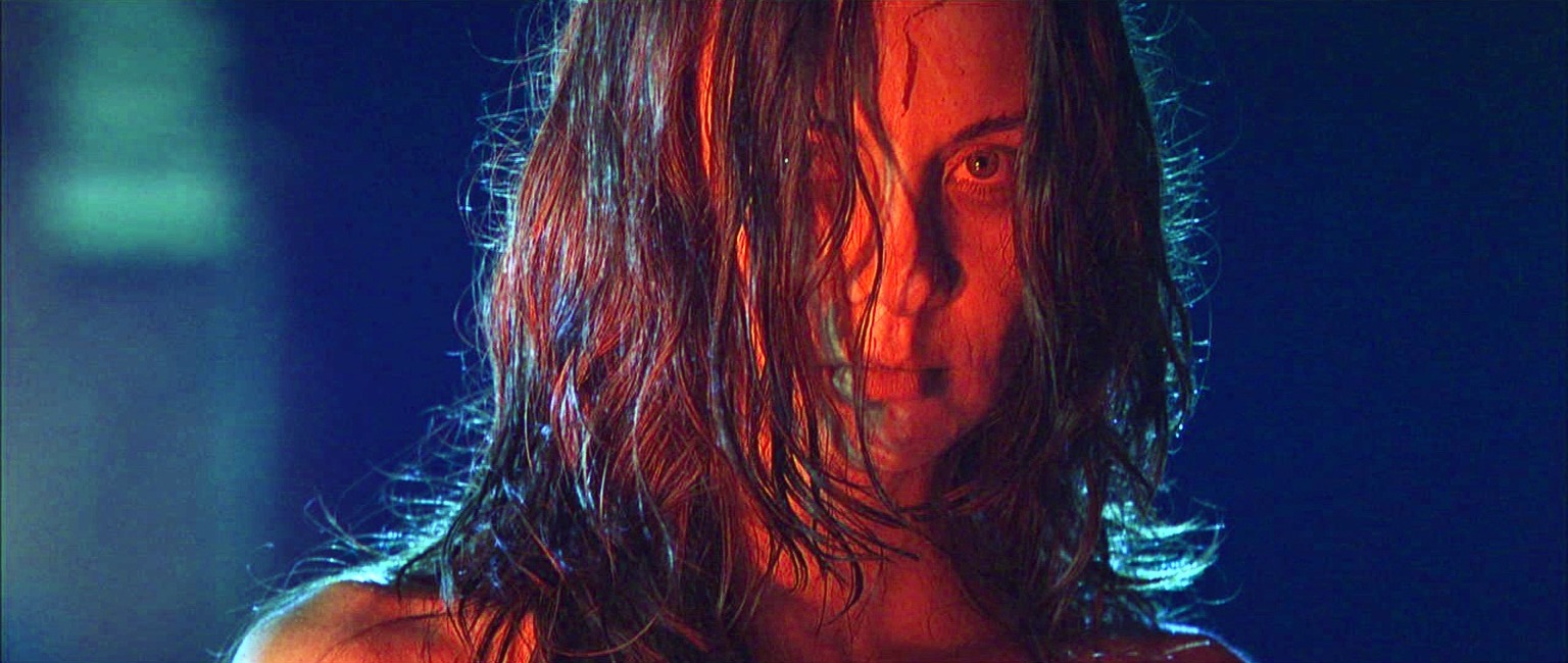 Mary stares forward under red and blue light