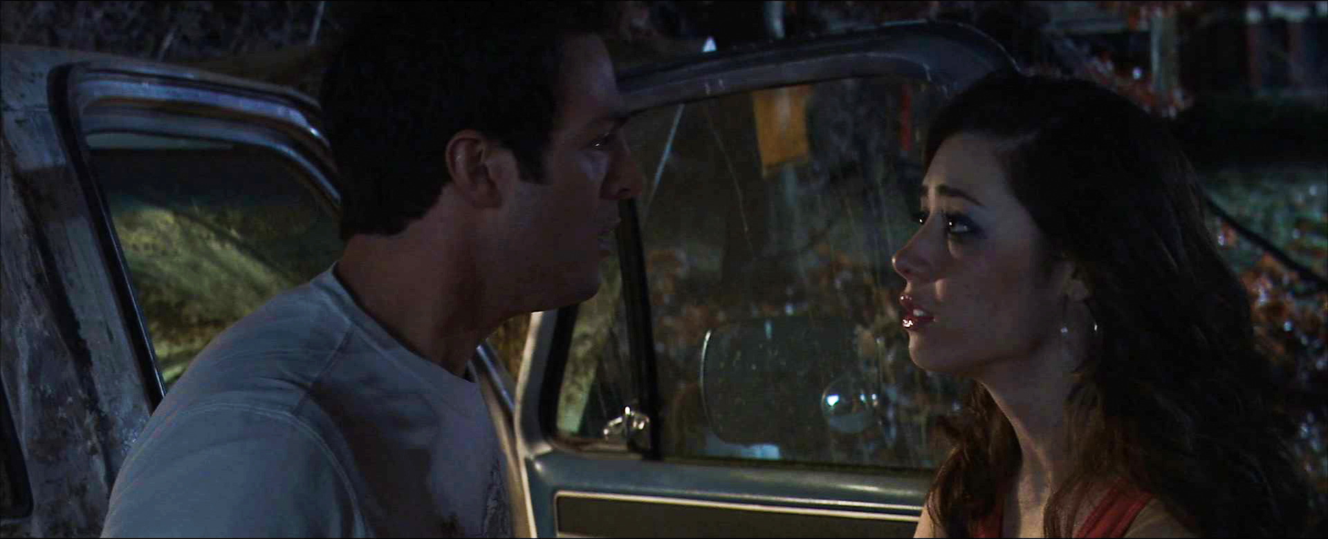 Chris and Nicole speak beside the van outside the sanitarium
